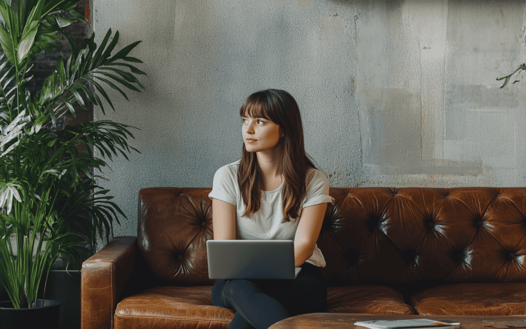 a young woman sits on a couch with her laptop open, thinking about how to write a blog in the right way